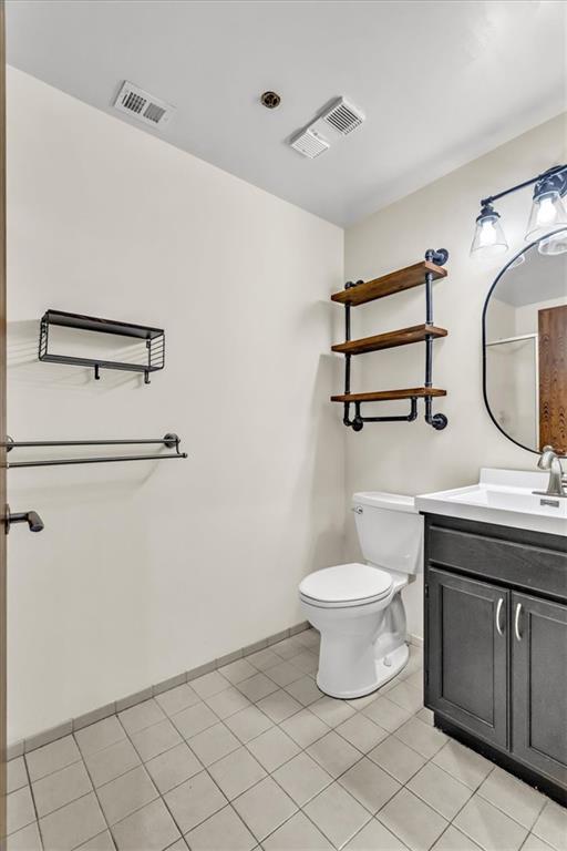 200 Main St Unit 211, Kansas City, MO 64105 - bathroom featuring vanity, toilet, baseboards, and tile patterned flooring