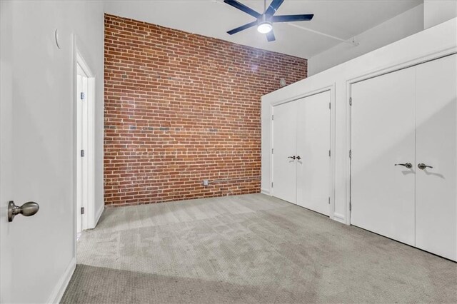200 Main St Unit 211, Kansas City, MO 64105 - unfurnished bedroom with brick wall, carpet floors, and a ceiling fan