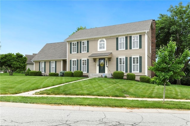 10500 Reeder St, Overland Park, KS 66214 - colonial house featuring a front lawn and a chimney