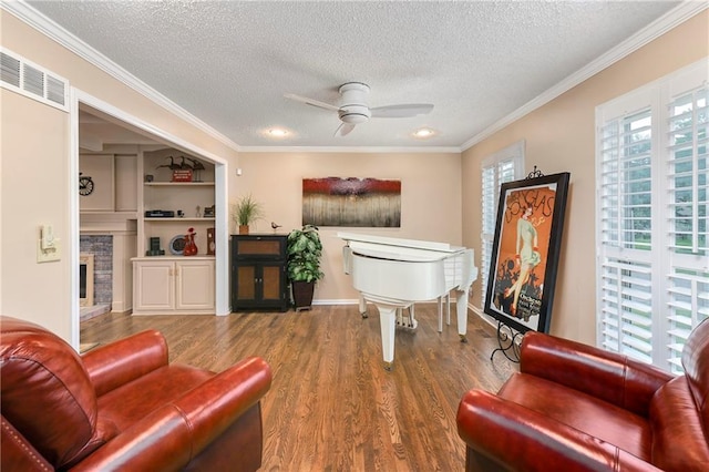10500 Reeder St, Overland Park, KS 66214 - living area with a textured ceiling, ceiling fan, wood finished floors, crown molding, and a stone fireplace