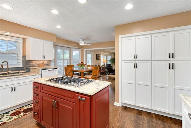 10500 Reeder St, Overland Park, KS 66214 - kitchen with a sink, stainless steel gas stovetop, dishwasher, dark wood-style floors, and a textured ceiling
