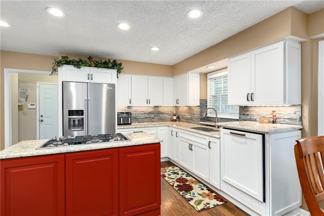 10500 Reeder St, Overland Park, KS 66214 - kitchen with stainless steel appliances, a sink, a kitchen island, a textured ceiling, and decorative backsplash