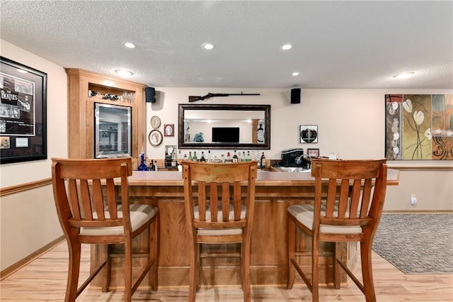 10500 Reeder St, Overland Park, KS 66214 - indoor wet bar with light wood-type flooring, beverage cooler, recessed lighting, a textured ceiling, and baseboards