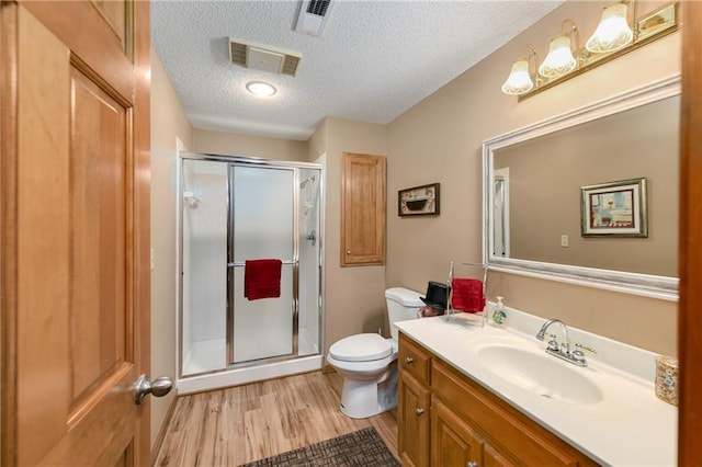 10500 Reeder St, Overland Park, KS 66214 - full bathroom with toilet, wood finished floors, vanity, a shower stall, and a textured ceiling