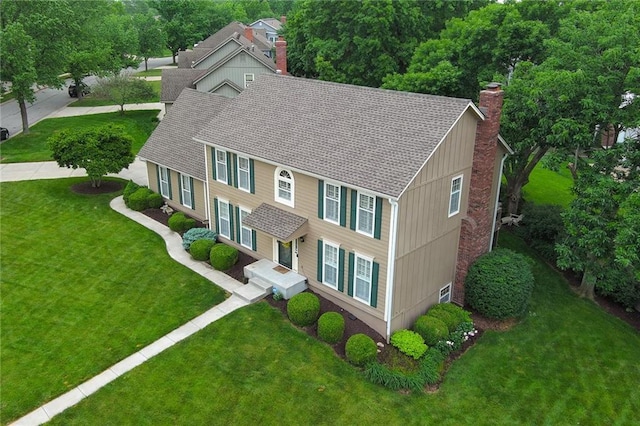 10500 Reeder St, Overland Park, KS 66214 - view of front of property featuring a chimney, a front yard, and a shingled roof
