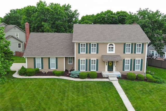 10500 Reeder St, Overland Park, KS 66214 - colonial inspired home featuring a front lawn, a chimney, and a shingled roof