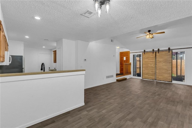 1528 E 123rd St, Olathe, KS 66061 - unfurnished living room with a textured ceiling, dark wood-style flooring, a ceiling fan, vaulted ceiling, and baseboards