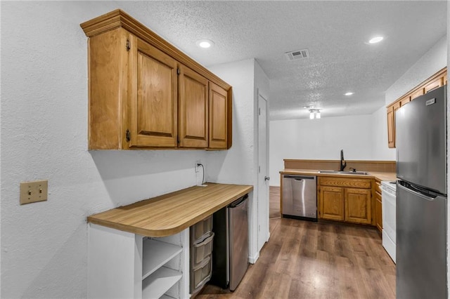 1528 E 123rd St, Olathe, KS 66061 - kitchen featuring stainless steel appliances, a sink, a textured ceiling, light countertops, and brown cabinetry
