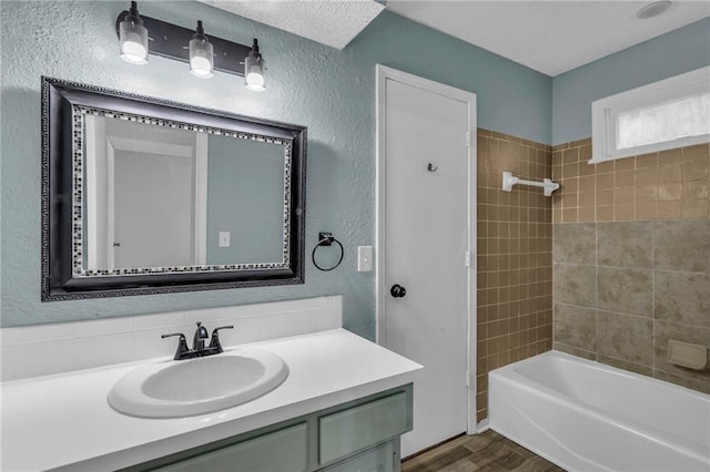 1528 E 123rd St, Olathe, KS 66061 - bathroom with vanity, wood finished floors, tub / shower combination, and a textured wall