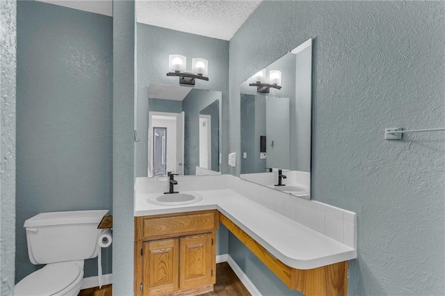 1528 E 123rd St, Olathe, KS 66061 - bathroom featuring a textured wall, wood finished floors, toilet, vanity, and a textured ceiling