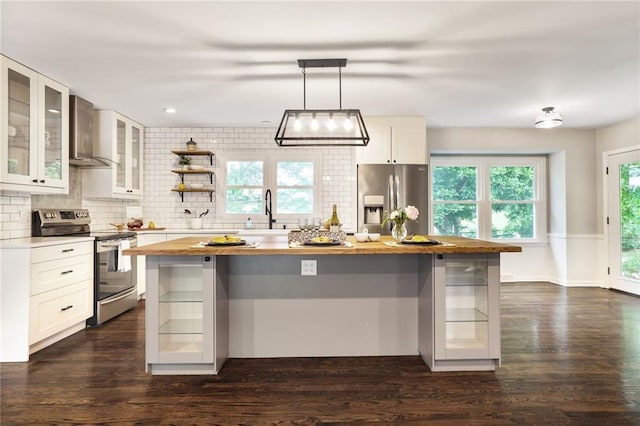 10416 Mohawk Ln, Leawood, KS 66206 - kitchen with stainless steel appliances, butcher block countertops, wall chimney range hood, decorative backsplash, and a center island
