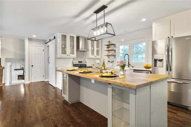 10416 Mohawk Ln, Leawood, KS 66206 - kitchen with stainless steel appliances, wood counters, wall chimney exhaust hood, backsplash, and white cabinetry