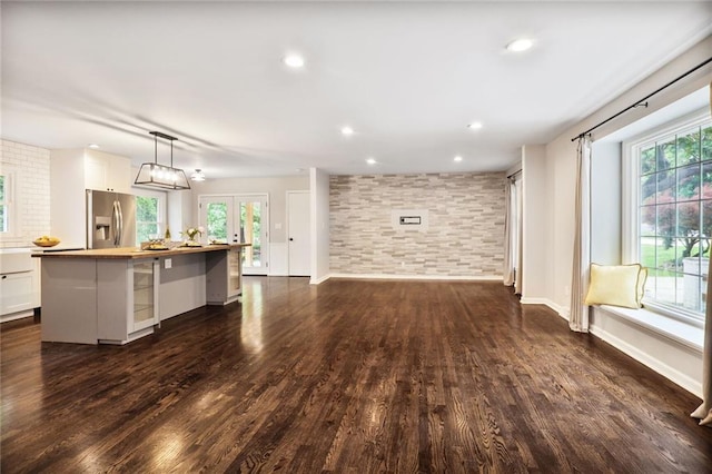 10416 Mohawk Ln, Leawood, KS 66206 - unfurnished living room featuring dark wood-type flooring, plenty of natural light, baseboards, recessed lighting, and french doors