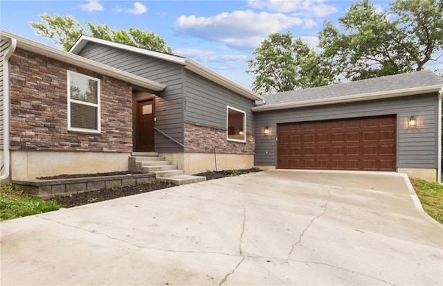131 Cedar Ct, Warrensburg, MO 64093 - view of front facade with a garage, driveway, entry steps, and stone siding