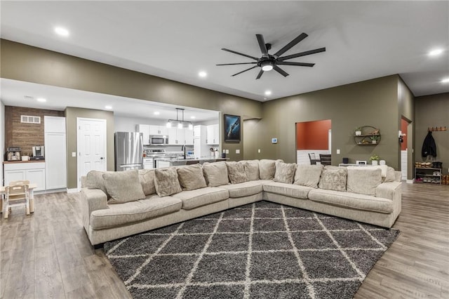 131 Cedar Ct, Warrensburg, MO 64093 - living area with wood finished floors, ceiling fan, and recessed lighting