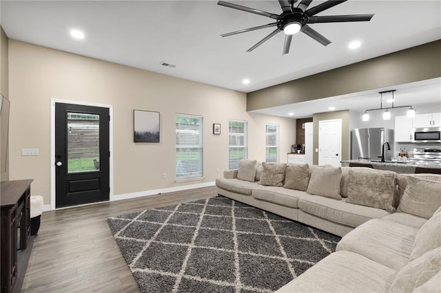 131 Cedar Ct, Warrensburg, MO 64093 - living area with dark wood-style floors, a ceiling fan, healthy amount of natural light, recessed lighting, and baseboards