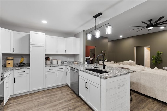 131 Cedar Ct, Warrensburg, MO 64093 - kitchen with stainless steel dishwasher, a sink, open floor plan, a peninsula, and white cabinets