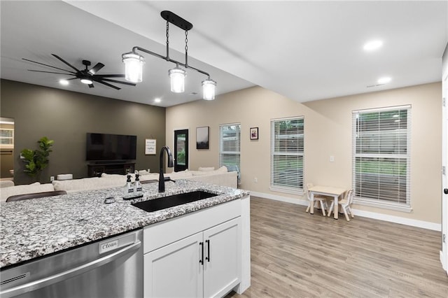 131 Cedar Ct, Warrensburg, MO 64093 - kitchen with stainless steel dishwasher, a sink, open floor plan, light stone countertops, and recessed lighting