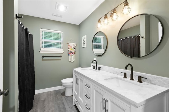 131 Cedar Ct, Warrensburg, MO 64093 - bathroom featuring double vanity, wood finished floors, toilet, and baseboards