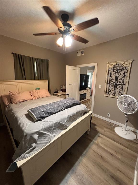620 S Evergreen Ave, Chanute, KS 66720 - bedroom featuring wood finished floors, baseboards, and ceiling fan