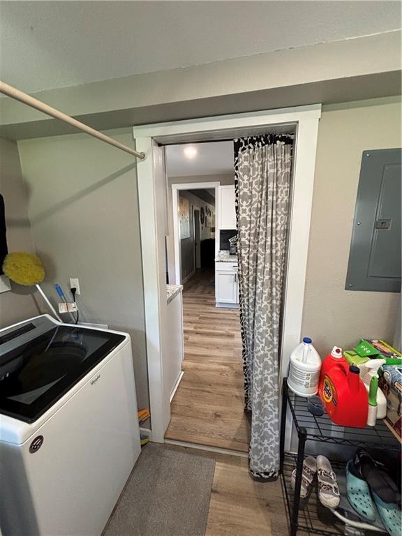 620 S Evergreen Ave, Chanute, KS 66720 - washroom featuring electric panel, washer / dryer, and light wood-type flooring