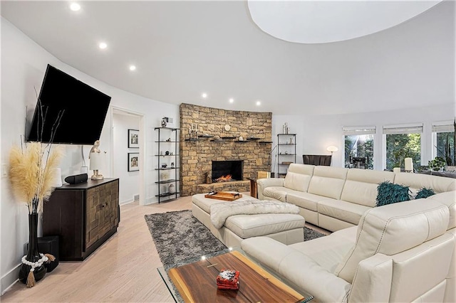 8201 W 100th Ter, Overland Park, KS 66212 - living room featuring recessed lighting, light wood-style flooring, a stone fireplace, and baseboards