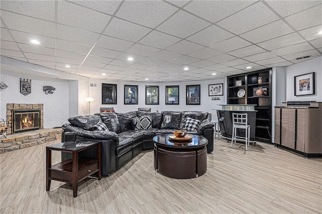 8201 W 100th Ter, Overland Park, KS 66212 - living room featuring wood finished floors, a fireplace, and a drop ceiling