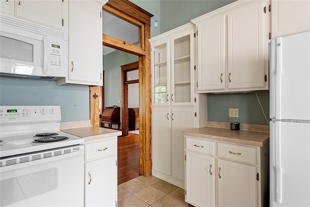 901 S 3rd St, Leavenworth, KS 66048 - kitchen featuring white appliances, light countertops, light tile patterned floors, and white cabinets