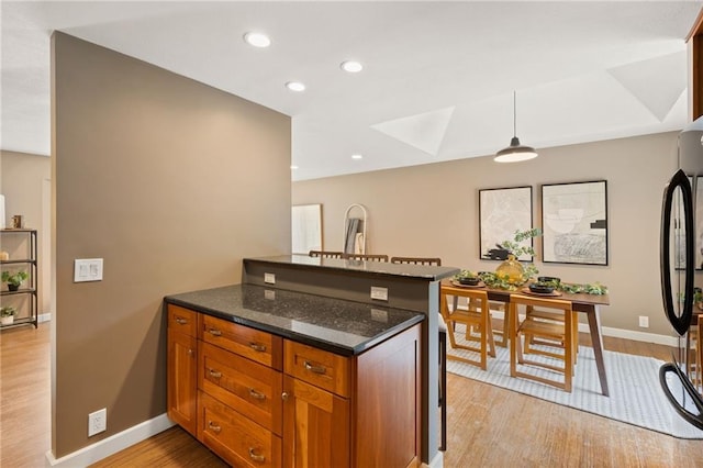 3601 NW 56th St, Houston Lake, MO 64151 - kitchen featuring a peninsula, light wood-style floors, baseboards, dark stone countertops, and recessed lighting