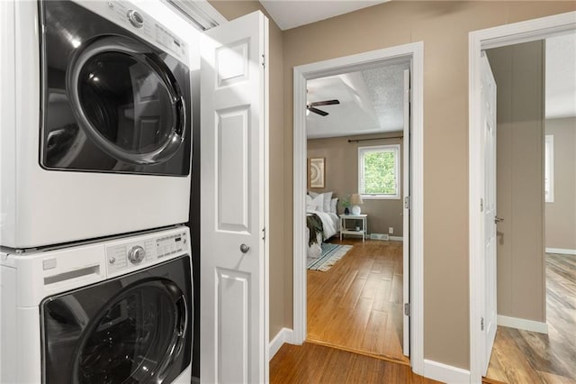 3601 NW 56th St, Houston Lake, MO 64151 - laundry area featuring stacked washer / dryer, wood finished floors, baseboards, and ceiling fan