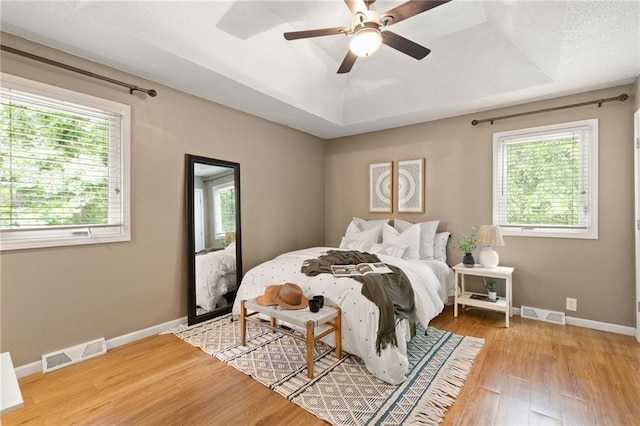 3601 NW 56th St, Houston Lake, MO 64151 - bedroom with wood finished floors, baseboards, a tray ceiling, and ceiling fan