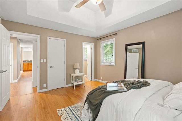 3601 NW 56th St, Houston Lake, MO 64151 - bedroom featuring light wood finished floors, a tray ceiling, baseboards, and ceiling fan