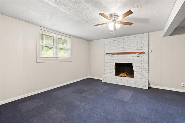 3601 NW 56th St, Houston Lake, MO 64151 - unfurnished living room featuring ceiling fan, a textured ceiling, a fireplace, dark carpet, and baseboards