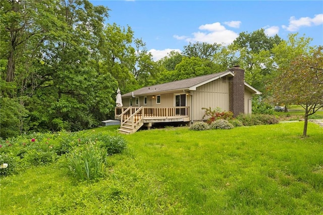 3601 NW 56th St, Houston Lake, MO 64151 - back of house featuring a chimney, a wooden deck, and a yard