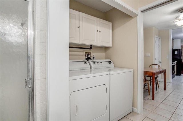 1501 Osage St, Leavenworth, KS 66048 - laundry room featuring washing machine and clothes dryer, cabinet space, light tile patterned flooring, and baseboards
