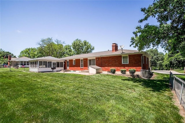 1501 Osage St, Leavenworth, KS 66048 - back of property featuring a sunroom, brick siding, a chimney, and a patio
