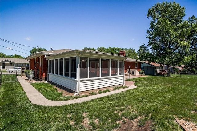 1501 Osage St, Leavenworth, KS 66048 - view of home's exterior with a sunroom, brick siding, and a chimney