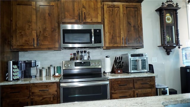 6418 N 141st St, Basehor, KS 66007 - kitchen featuring appliances with stainless steel finishes, tasteful backsplash, and light stone countertops