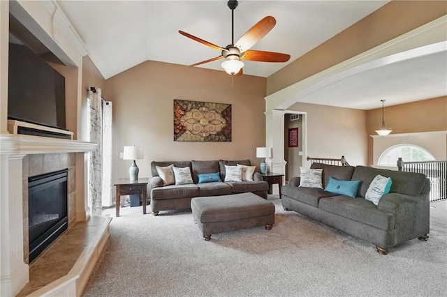 10136 N Wallace Ave, Kansas City, MO 64157 - carpeted living room with a ceiling fan, decorative columns, a tile fireplace, and vaulted ceiling