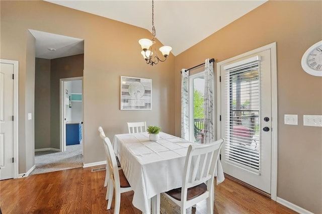 10136 N Wallace Ave, Kansas City, MO 64157 - dining space featuring a chandelier, lofted ceiling, wood finished floors, and baseboards
