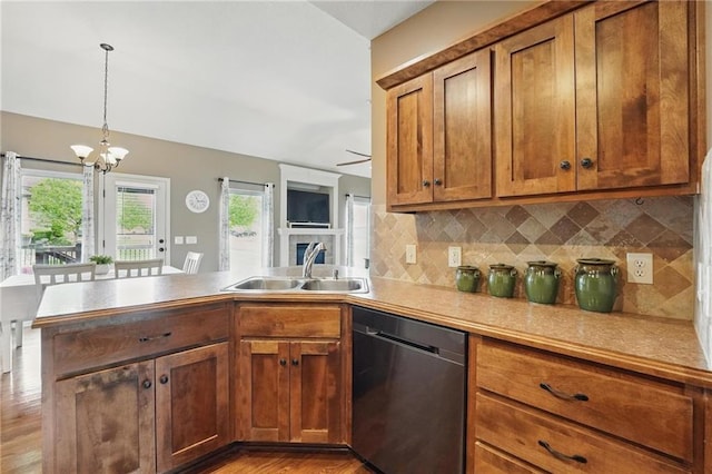 10136 N Wallace Ave, Kansas City, MO 64157 - kitchen featuring dishwasher, a peninsula, a sink, brown cabinetry, and decorative backsplash