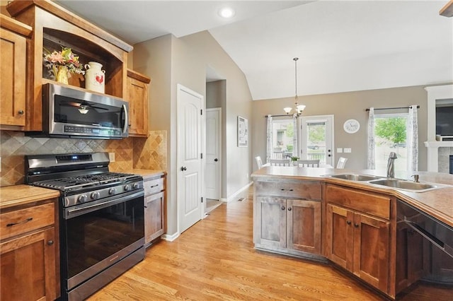 10136 N Wallace Ave, Kansas City, MO 64157 - kitchen with stainless steel appliances, a sink, lofted ceiling, light wood-style floors, and tasteful backsplash