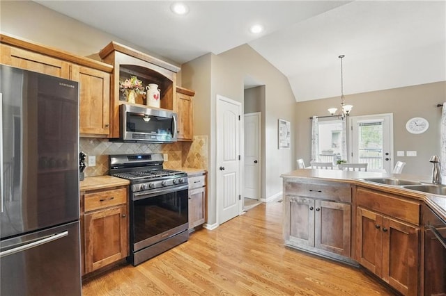10136 N Wallace Ave, Kansas City, MO 64157 - kitchen featuring appliances with stainless steel finishes, a sink, vaulted ceiling, tasteful backsplash, and light wood-type flooring