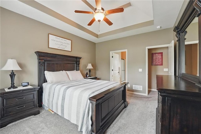 10136 N Wallace Ave, Kansas City, MO 64157 - bedroom featuring light carpet, a tray ceiling, baseboards, ceiling fan, and ensuite bathroom