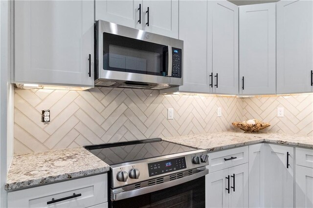 18 Beechwood Ln, Linn Valley, KS 66040 - kitchen with appliances with stainless steel finishes, backsplash, light stone counters, and white cabinetry