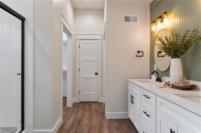 18 Beechwood Ln, Linn Valley, KS 66040 - bathroom with wood finished floors, double vanity, baseboards, a stall shower, and a closet