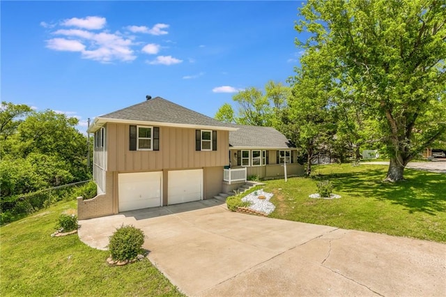 10908 Indiana Ave, Kansas City, MO 64137 - split level home featuring an attached garage, concrete driveway, a front lawn, and board and batten siding