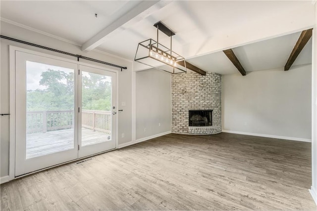 10908 Indiana Ave, Kansas City, MO 64137 - unfurnished living room featuring beam ceiling, wood finished floors, baseboards, and a brick fireplace