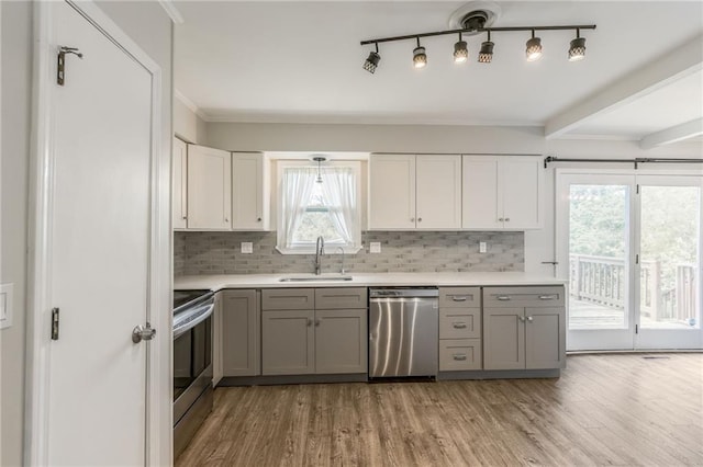 10908 Indiana Ave, Kansas City, MO 64137 - kitchen featuring appliances with stainless steel finishes, a sink, gray cabinets, light wood-type flooring, and light countertops