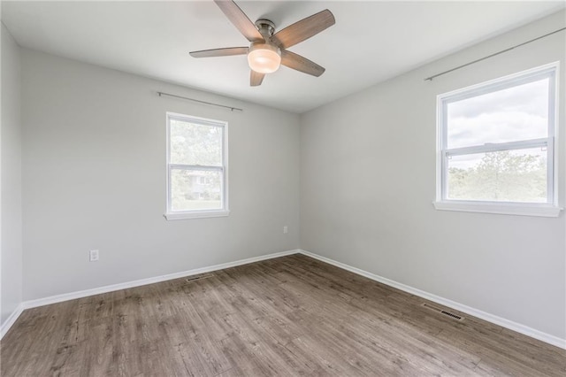 10908 Indiana Ave, Kansas City, MO 64137 - spare room featuring plenty of natural light, wood finished floors, baseboards, and ceiling fan